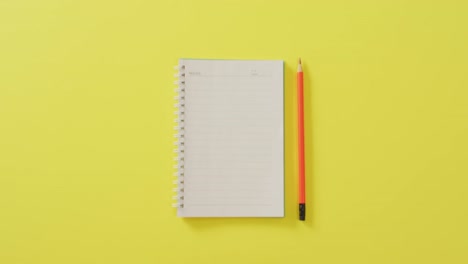 Video-Eines-Notizbuchs-Mit-Kopierraum-Und-Bleistift-Auf-Gelbem-Hintergrund