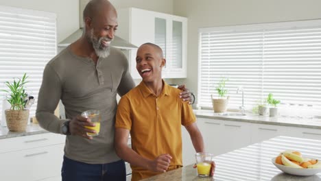 Video-Eines-Glücklichen-Afroamerikanischen-Vaters-Und-Sohnes,-Der-In-Der-Küche-Lacht
