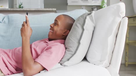 Video-Eines-Glücklichen-Afroamerikanischen-Jungen,-Der-Sein-Smartphone-Auf-Dem-Sofa-Benutzt