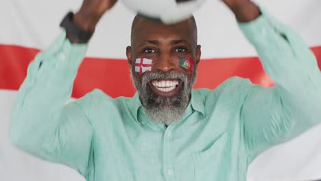 Video-Eines-Glücklichen-Afroamerikanischen-Mannes-Mit-Flaggen-über-Der-Englischen-Flagge,-Der-Sich-Ein-Spiel-Ansieht