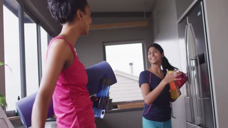Video-of-happy-biracial-female-friends-preparing-for-practicing-yoga