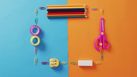 Video-of-frame-made-of-school-equipment-on-blue-and-orange-surface