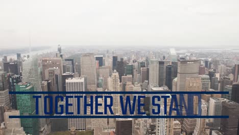 Animation-of-together-we-stand-text-over-skyscrapers-in-modern-cityscape