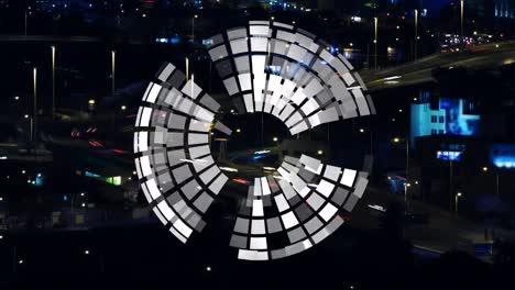 Animation-of-globe-made-of-white-lights-rotating-over-blurred-night-cityscape