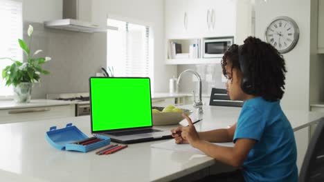 Animación-De-Un-Niño-Birracial-Con-Auriculares-Que-Tiene-Lecciones-En-Línea-En-Una-Computadora-Portátil-Con-Espacio-Para-Copiar-En-Casa
