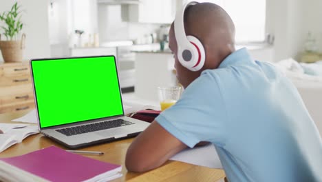 Animation-of-african-american-boy-in-headphones-having-online-lessons-on-laptop-with-copy-space