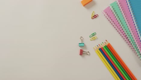 Video-of-composition-of-school-items-on-white-surface-with-copy-space