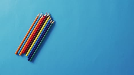 Video-of-colorful-crayons-lying-on-blue-surface
