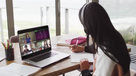 Biracial-Teenager-Mädchen-Nutzt-Laptop-Für-Videoanrufe,-Mit-Männlichem-Lehrer-Und-Klasse-Auf-Dem-Bildschirm