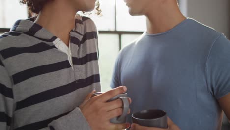 Glückliches,-Vielfältiges-Männliches-Paar,-Das-Kaffee-Trinkt-Und-Sich-In-Der-Küche-Umarmt