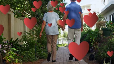 Animation-of-falling-hearts-over-caucasian-senior-couple-walking