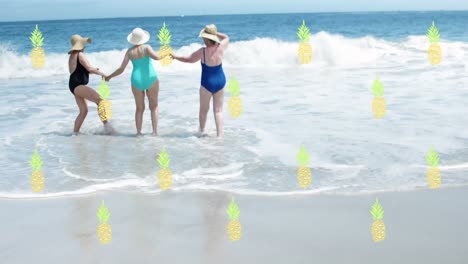 Animation-of-falling-pineapples-over-caucasian-senior-group-of-woman-on-the-beach