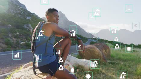 Animation-of-eco-icons-over-african-american-male-hiker-looking-at-landscape