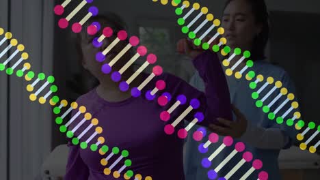 Animation-Von-DNA-Strängen-über-Einer-Asiatischen-Physiotherapeutin,-Die-Einen-Patienten-Behandelt