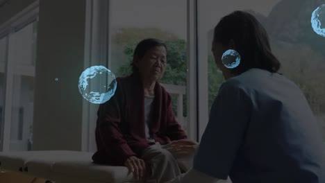 Animation-Von-Flecken-über-Einer-Asiatischen-Ärztin,-Die-Mit-Einem-älteren-Patienten-Spricht