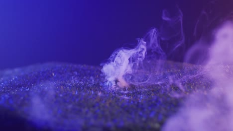 Video-of-hand-raising-from-grass-with-smoke-on-black-background