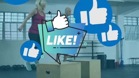 Animation-of-like-text-and-thumb-up-symbols-over-caucasian-man-and-woman-jumping-on-boxes-in-gym