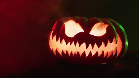 Video-of-halloween-carved-pumpkin-with-smoke-and-red-light-on-black-background