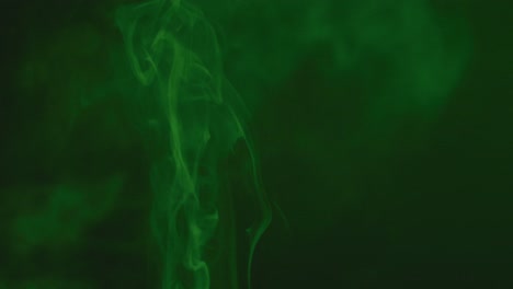 Video-of-white-smoke-with-green-light-moving-on-black-background
