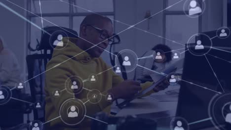 Animation-of-connections-with-digital-icons-over-african-american-businessman-in-office