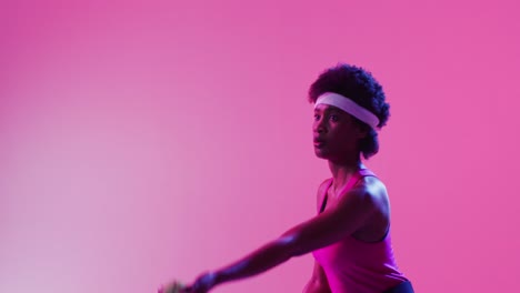 Video-Einer-Fokussierten-Afroamerikanischen-Tennisspielerin,-Die-Den-Ball-Auf-Neonpinken-Blitzen-Schlägt