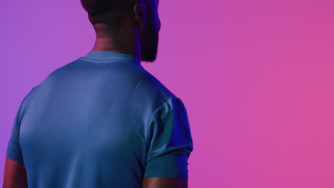 Video-of-back-view-of-african-american-male-tennis-player-in-neon-pink-lightning