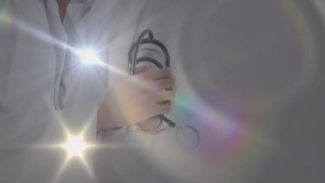 Animation-Von-Lichtflecken-über-Einem-Kaukasischen-Arzt-Mit-Stethoskop