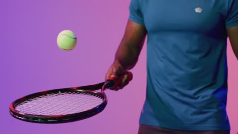 Video-Des-Mittelteils-Eines-Afroamerikanischen-Männlichen-Tennisspielers,-Der-In-Neonrosa-Blitzen-Einen-Ball-Hüpft