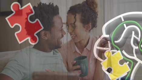 Animation-of-colourful-puzzle-over-biracial-couple-with-tablet