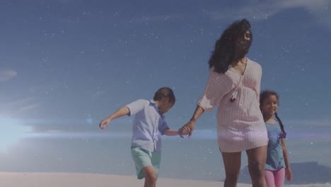 Animation-of-light-trails-over-biracial-woman-with-her-children-walking-at-beach