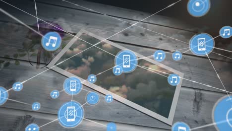 Animation-of-network-of-connections-with-icons-over-tablet-and-sky-with-clouds