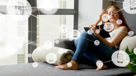 Animation-of-network-of-connections-with-icons-over-caucasian-woman-reading