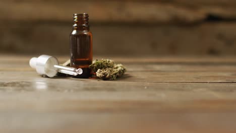Video-of-marijuana-buds-and-bottle-of-cbd-extract-on-wooden-background