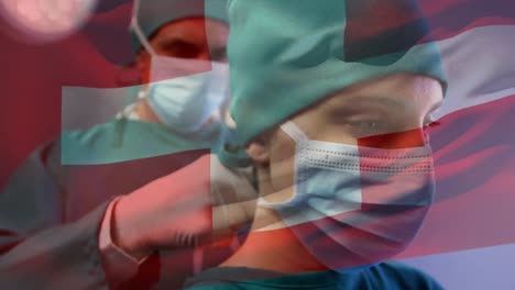 Animation-of-flag-of-switzerland-over-caucasian-male-surgeon-tying-face-mask-to-female-colleague