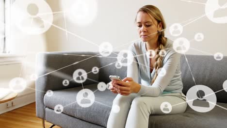 Animation-of-profile-icons-interconnecting-with-lines-over-caucasian-woman-using-cellphone-on-sofa