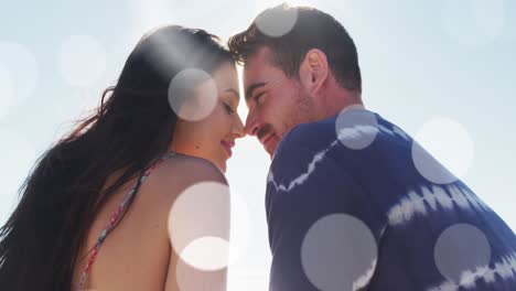 Animation-of-dots-over-happy-caucasian-couple-kissing-on-beach