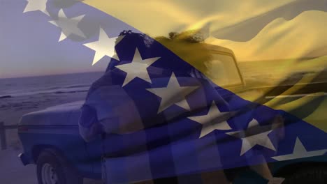 Die-Flagge-Von-Bosnien-Und-Herzegowina-Weht-über-Der-Rückansicht-Eines-Afroamerikanischen-Paares,-Das-Am-Strand-Genießt