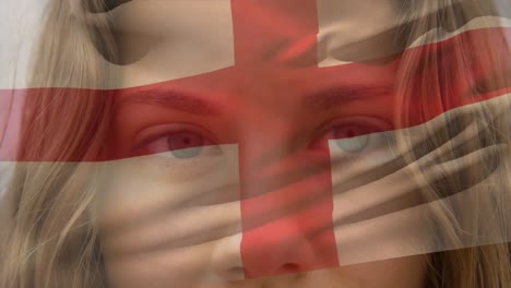 Animation-of-flag-of-england-over-caucasian-woman-at-beach
