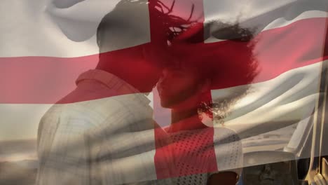 Animation-of-england-flag-waving-over-happy-african-american-couple-romancing-at-beach