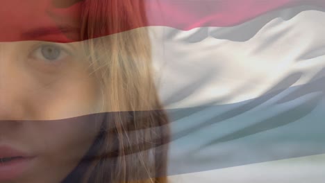 Animation-of-flag-of-netherlands-over-woman-wearing-face-mask