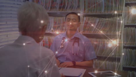 Animación-De-Puntos-Iluminados-Que-Se-Conectan-Con-Líneas-Sobre-Un-Médico-Asiático-Que-Consulta-A-Un-Paciente-Mayor