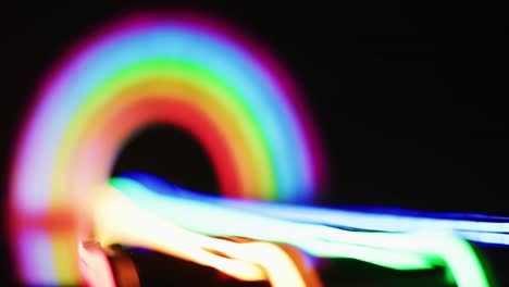 Animation-of-colorful-neon-lights-forming-rainbow-on-black-background