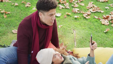 Video-of-biracial-couple-warmly-spending-time-in-the-garden-and-using-smartphone
