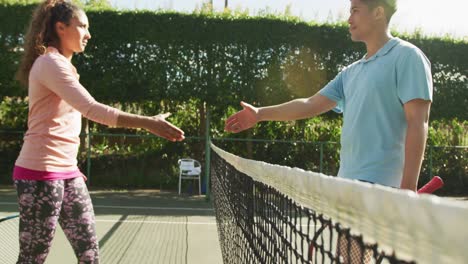Video-Eines-Glücklichen-Gemischtrassigen-Paares,-Das-Auf-Dem-Platz-Tennis-Spielt