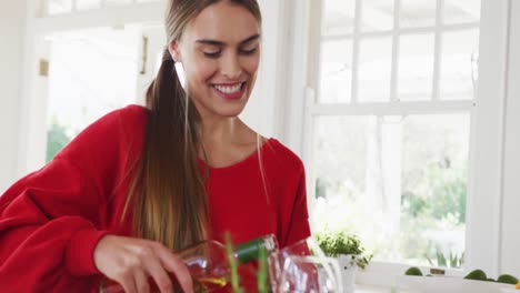 Video-of-happy-caucasian-women-drinking-wine-in-the-kitchen