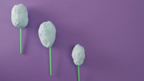 Video-Von-Marshmallows-Auf-Stöcken,-Die-Auf-Einer-Violetten-Oberfläche-Liegen