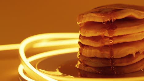 Video-of-maple-syrup-pouring-into-pancakes-on-orange-background