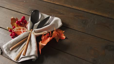 Video-of-cutlery,cloth-and-autumn-decoration-lying-on-wooden-surface