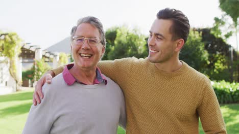 Video-of-happy-senior-caucasian-father-and-adult-son-embracing-in-sunny-garden