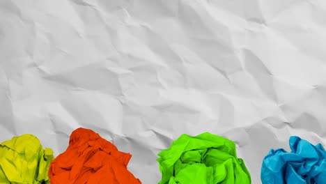 Animation-yellow,-red,-green-and-blue-balls-of-paper-over-moving-scrunched-white-paper-texture
